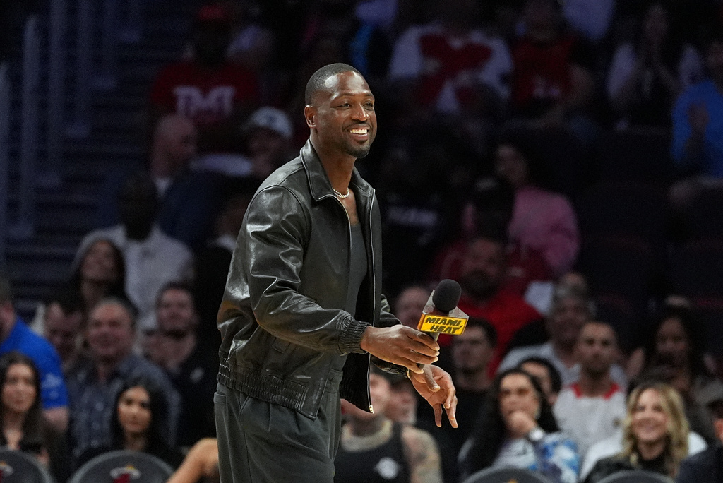 Miami Heat legend Dwyane Wade walks on the court during a time out while watching an NBA basketball game between the Miami Heat and the Dallas Mavericks, Monday, Oct. 26, 2026, in Miami. (AP Photo/Rebecca Blackwell)