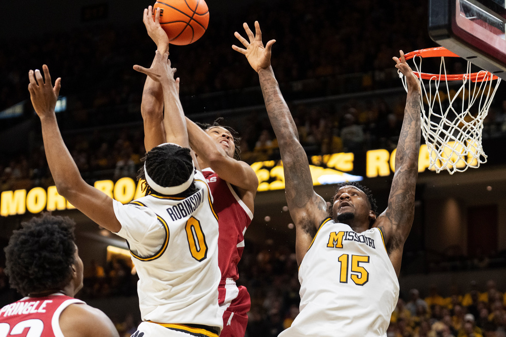 Arkansas' D.J. Wagner, center, shoots over Missouri's Shawn Phillips Jr. (15) and Anthony Robinson II (0) during the first half of an NCAA college basketball game Saturday, March 7, 2026, in Columbia, Mo. (AP Photo/L.G. Patterson)
