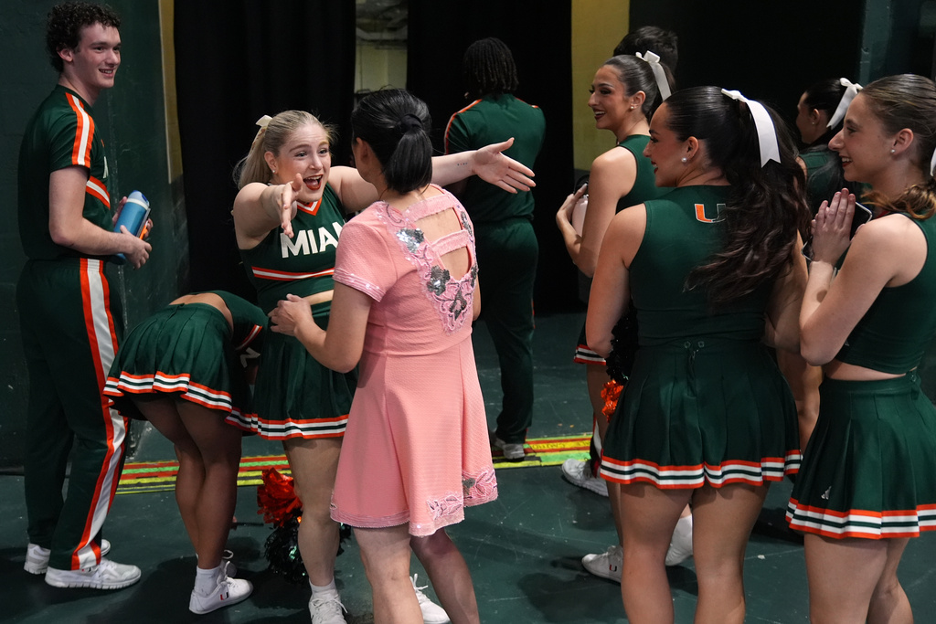 Miami cheerleaders react as they meet Red Panda after she performed at halftime of an NCAA college basketball game between Miami and Stanford in Coral Gables, Fla., Wednesday, Jan. 28, 2026. (AP Photo/Rebecca Blackwell)