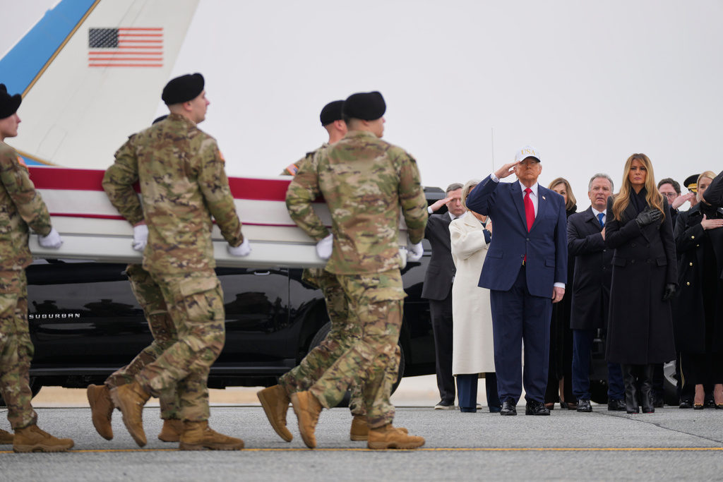 An Army carry team moves a flag-draped transfer case with the remains of Sgt. Declan Coady, 20, of West Des Moines, Iowa, who was killed in a drone strike at a command center in Kuwait after the U.S. and Israel launched its military campaign against Iran, past President Donald Trump and first lady Melania Trump during a casualty return, Saturday, March 7, 2026, at Dover Air Force Base, Del. (AP Photo/Mark Schiefelbein)