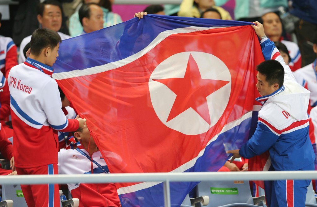 FILE - North Korea's delegation members prepare to spread the North Korean flag during their women's soccer final match at the 17th Asian Games in Incheon, South Korea, Oct. 1, 2014. (AP Photo/Eugene Hoshiko, File)