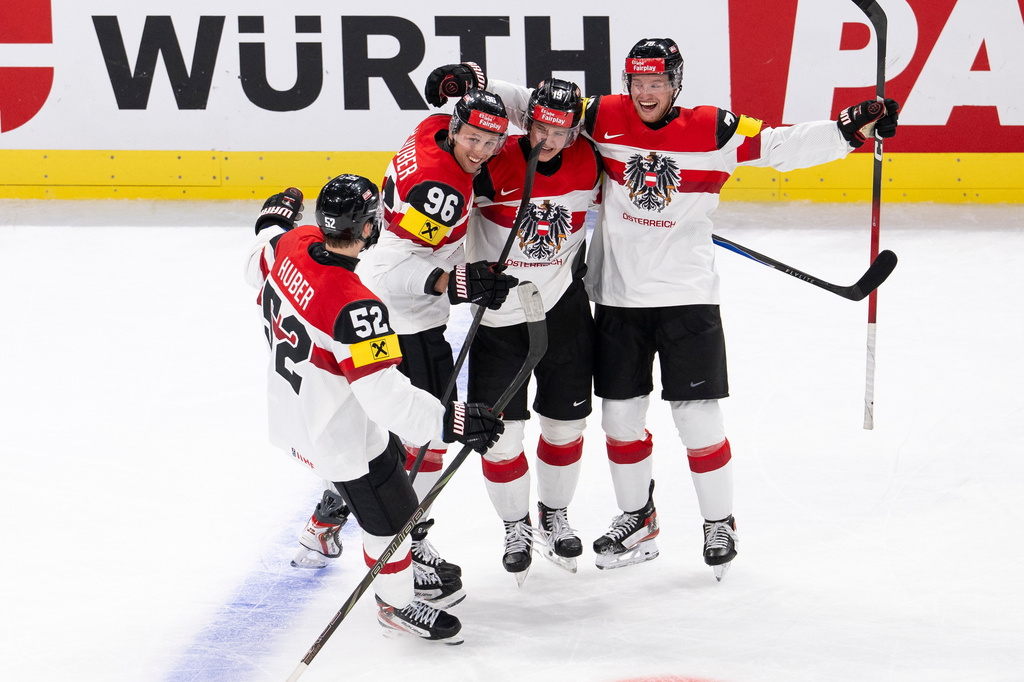 Austria's Vinzenz Rohrer, 2nd right, celebrates scoring with Paul Huber, left, Mario Huber and Thimo Nickl, right, during the Men's Ice Hockey World Championship preliminary round game between Latvia and Austria, in Zurich, Switzerland, Tuesday May 19, 2026. (Andreas Becker/Keystone via AP)