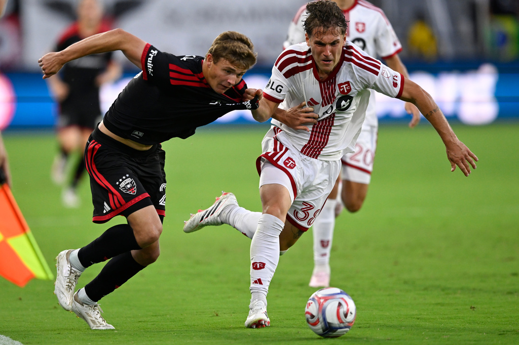 D.C. United midfield Jackson Hopkins, left, and Toronto FC defense Jackson Gilman, right, compete for the ball during the first half of an MLS soccer match, Saturday, July 25, 2026, in Washington. (AP Photo/John McDonnell)