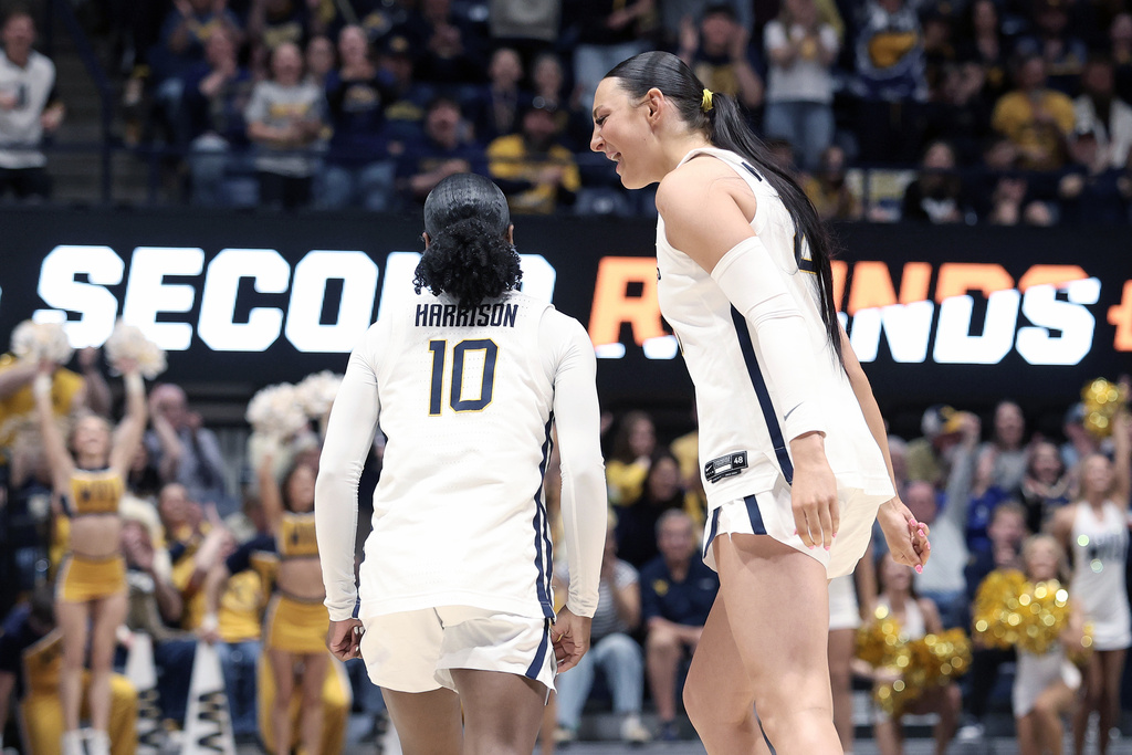 West Virginia forward Riley Makalusky, right, and guard Jordan Harrison (10) react in the first half against Miami (Ohio) in the first round of the NCAA college basketball tournament, Saturday, March 21, 2026, in Morgantown, W.Va. (AP Photo/Kathleen Batten)