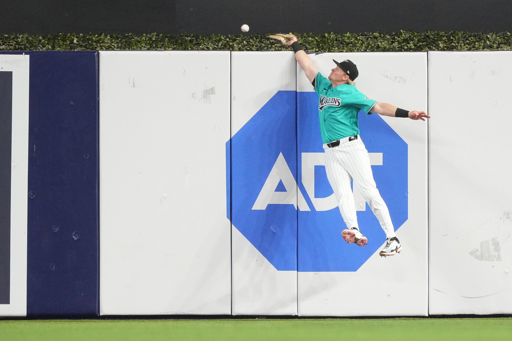 Miami Marlins right fielder Kyle Stowers attempts to catch a home run hit by Philadelphia Phillies' Bryson Stott in the first inning of a baseball game, Sunday, May 3, 2026, in Miami. (AP Photo/Jim Rassol)