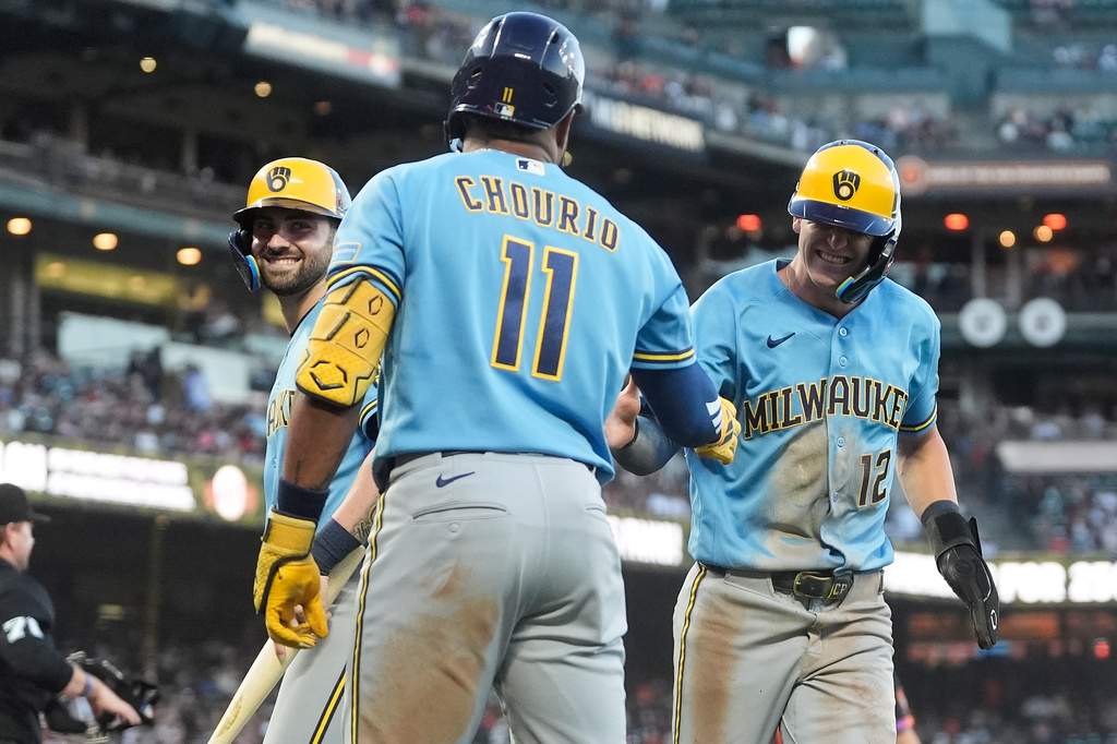 Milwaukee Brewers' Cooper Pratt, right, and Garrett Mitchell, left, are congratulated by Jackson Chourio (11) after both scored on a two-run single hit by Brice Turang during the fourth inning of a baseball game against the San Francisco Giants, Tuesday, July 28, 2026, in San Francisco. (AP Photo/Jeff Chiu)