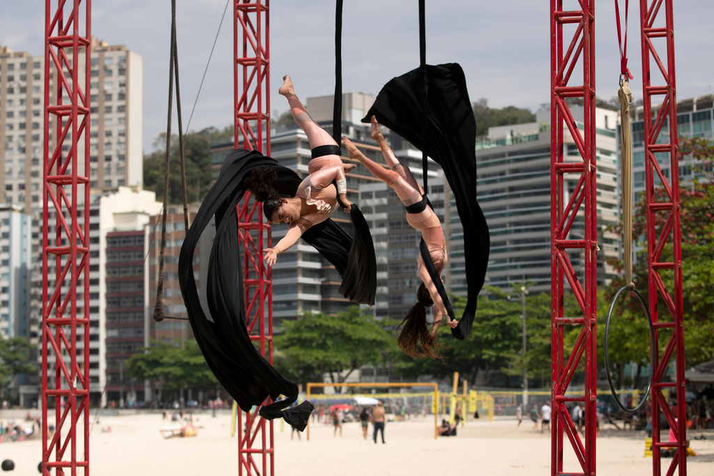 Members of the aerial circus group "Pendurados” perform in an open-air show that explores healing from sexual violence through art and community, at Icarai Beach in Niteroi, Rio de Janeiro state, Brazil, Saturday, Oct. 18, 2025. (AP Photo/Bruna Prado)
