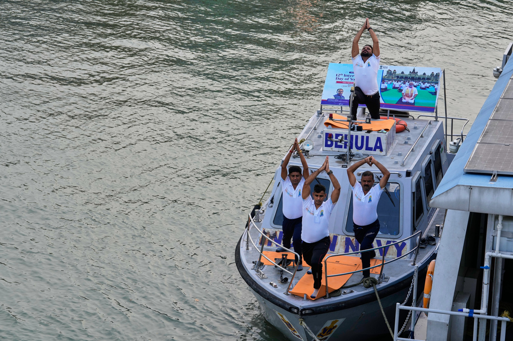 Indian Navy persons perform yoga on International Yoga Day on a Navy patrol boat on Hooghly River in Kolkata, India, Sunday, June 21, 2026. (AP Photo/Bikas Das)