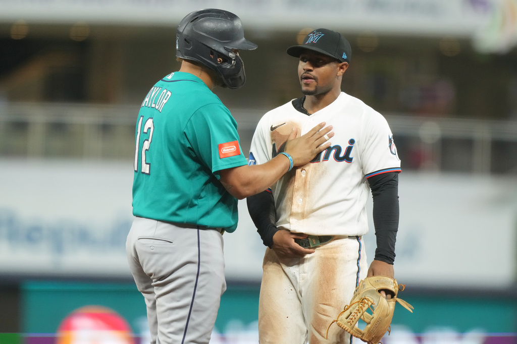 Seattle Mariners' Josh Naylor (12) and Miami Marlins second baseman Xavier Edwards exchange words during the eighth inning of a baseball game Tuesday, July 7, 2026, in Miami. (AP Photo/Marta Lavandier)