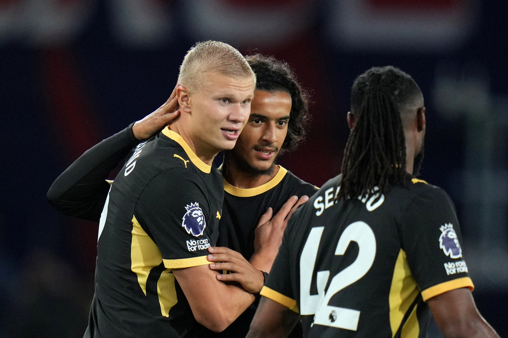 Manchester City's Erling Haaland, left, celebrates with Avyoub Bouaddi and Antoine Semenyo, right, after scoring his side's fourth goal during the English Premier League soccer match between Crystal Palace and Manchester City in London, Friday, Aug. 28, 2026. (AP Photo/Kin Cheung)