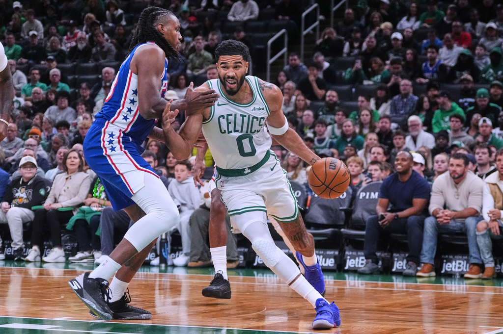 Boston Celtics forward Jayson Tatum (0) drives to the basket against Philadelphia 76ers forward Jabari Walker, left, during the first half of a preseason NBA basketball game, Saturday, Oct. 10, 2026, in Boston. (AP Photo/Charles Krupa)