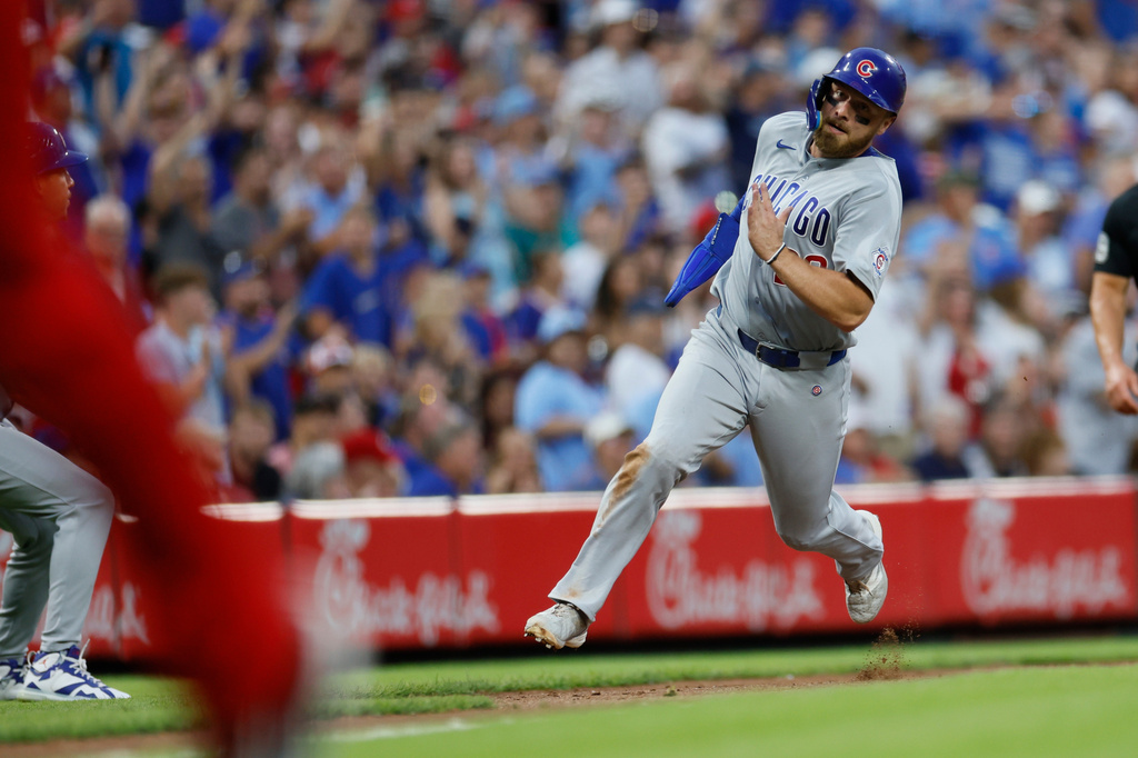 Chicago Cubs' Michael Busch runs to score from first base on a hit by teammate Ian Happ during the sixth inning of a baseball game against the Cincinnati Reds, Saturday, July 11, 2026, in Cincinnati. (AP Photo/Jay LaPrete)