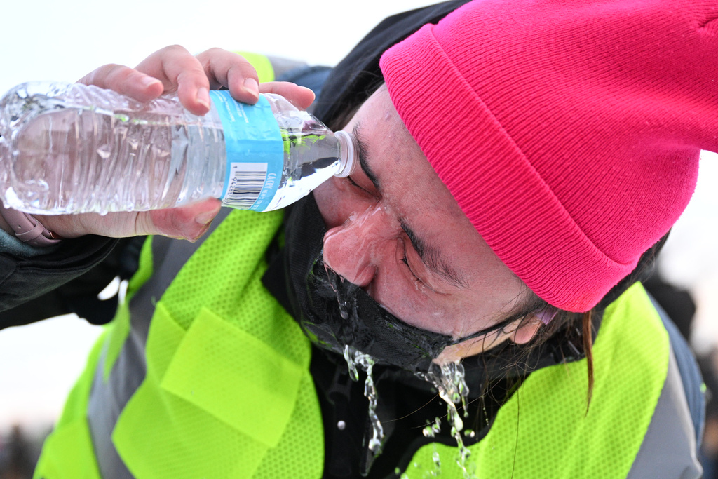 A protester pours water in their eye after confronting law enforcement outside the Bishop Henry Whipple Federal Building, Thursday, Jan. 8, 2026, in Minneapolis, Minn. (AP Photo/Tom Baker)