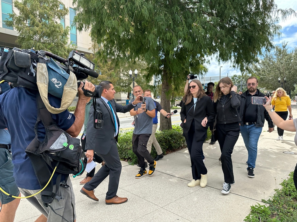 Siblings of a suspect charged in California's deadly Palisades fire walk outside of a federal courthouse in Orlando, Fla. after their brother, Jonathan Rinderknecht, was ordered to remain in jail during a detention hearing on Oct. 9, 2025. (AP Photo/Mike Schneider)