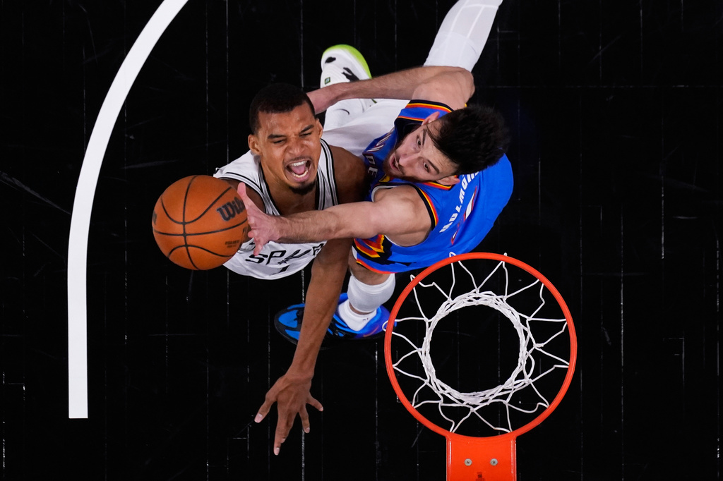 San Antonio Spurs forward Victor Wembanyama, left, scores against Oklahoma City Thunder center Chet Holmgren, right, during the first half in Game 4 in the Western Conference finals NBA basketball playoffs series in San Antonio, Sunday, May 24, 2026. (AP Photo/Eric Gay)