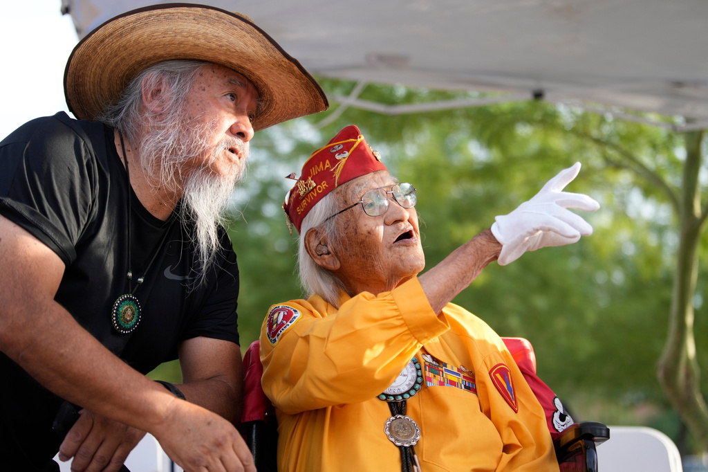 Navajo Code Talker Thomas Begay, right, talks with his son, Ron Begay, prior to a ceremony on Navajo Code Talkers Day, Friday, Aug. 14, 2026, in Phoenix. (AP Photo/Ross D. Franklin)