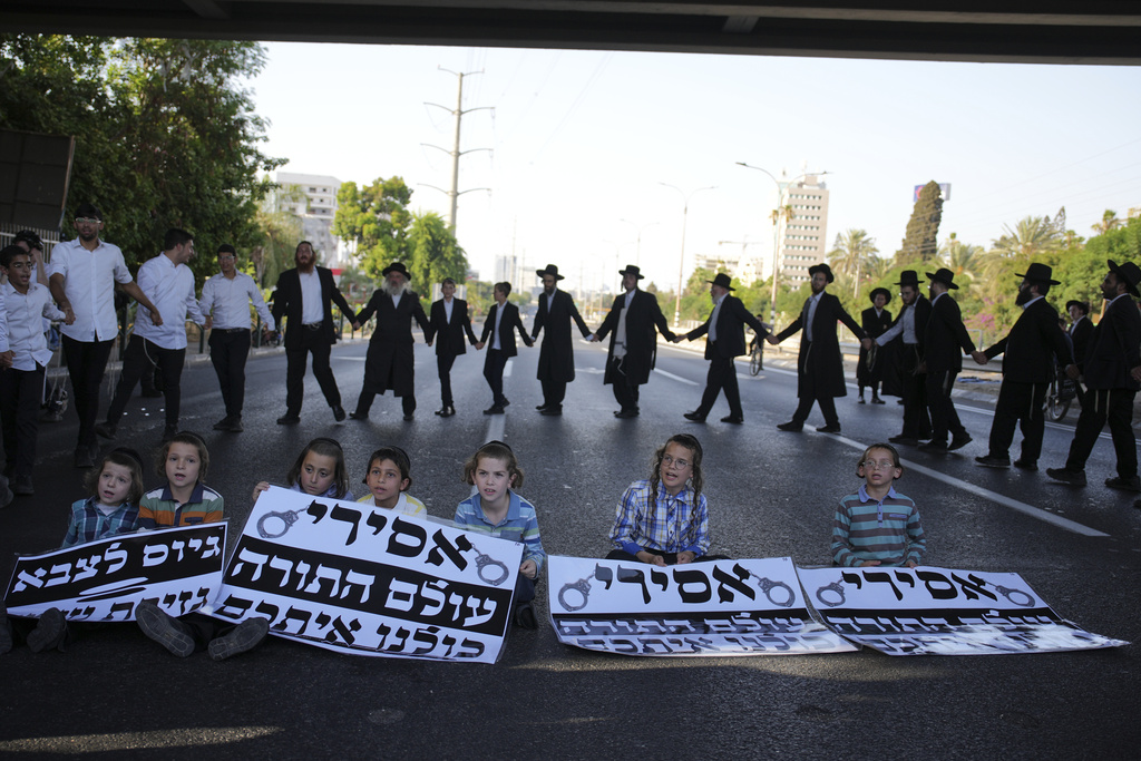 Ultra-Orthodox Jews block a highway during a protest against army recruitment, in Bnei Brak, Israel, Tuesday, Aug. 19, 2025. (AP Photo/Ohad Zwigenberg)