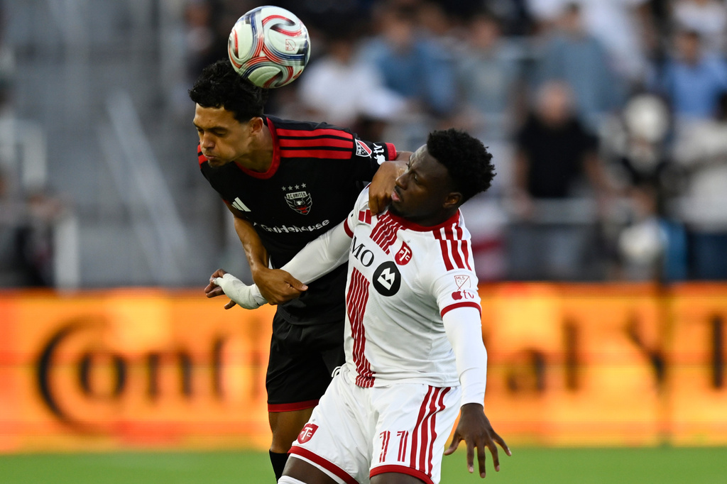 D.C. United midfield Andre Dozzell, left, heads the ball against Toronto FC midfield Derrick Etienne Jr., right, during the first half of an MLS soccer match, Saturday, July 25, 2026, in Washington. (AP Photo/John McDonnell)