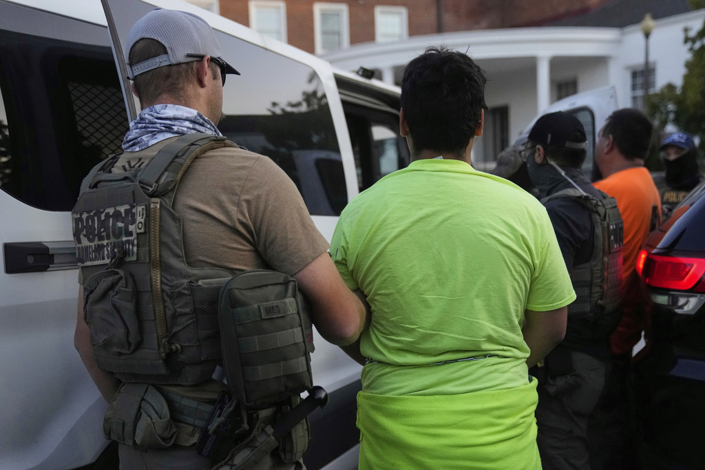 U.S. Immigration and Customs Enforcement agents make an arrest during an early morning operation in Park Ridge, Ill., Friday, Sept. 19, 2025. (AP Photo/Erin Hooley)