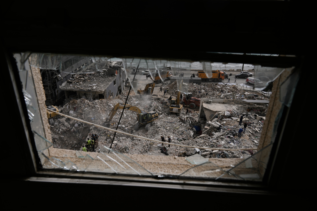 Excavators remove rubble from destroyed buildings that were hit on Thursday by Israeli airstrikes, as they keep searching for victims in Tyre city, southern Lebanon, Saturday, April 18, 2026. (AP Photo/Bilal Hussein)