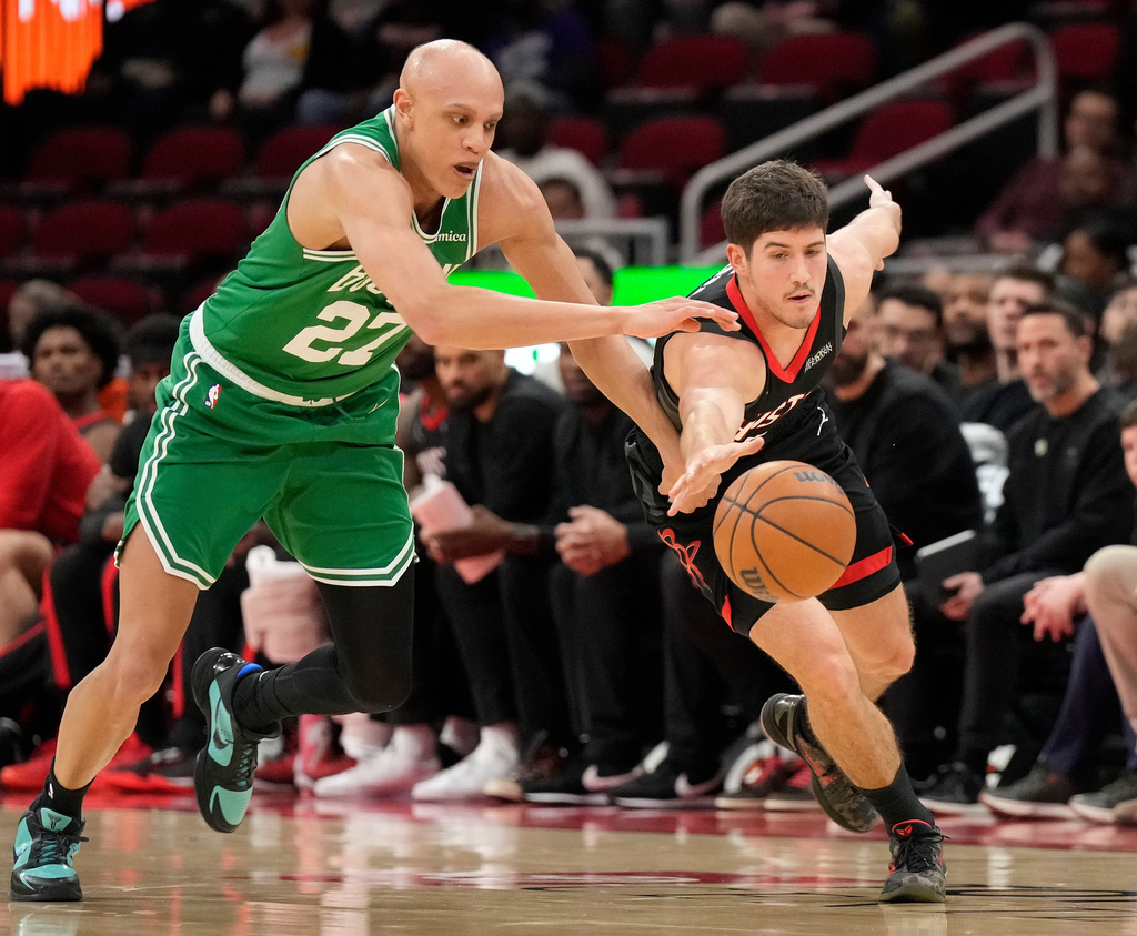 Houston Rockets guard Reed Sheppard, right, reaches for a loose ball against Boston Celtics forward Jordan Walsh (27) during the first half of an NBA basketball game, in Houston, Wednesday, Feb. 4, 2026. (AP Photo/ Karen Warren)