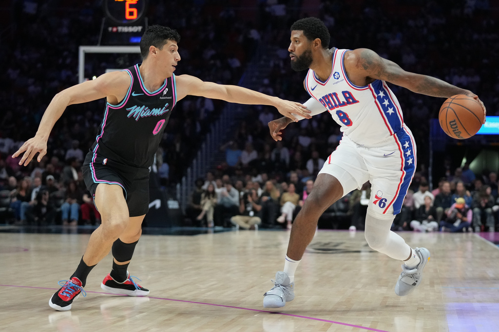 Philadelphia 76ers forward Paul George (8) controls the ball as Miami Heat forward Simone Fontecchio (0) defends during the first half of an NBA basketball game, Monday, March 30, 2026, in Miami. (AP Photo/Lynne Sladky)