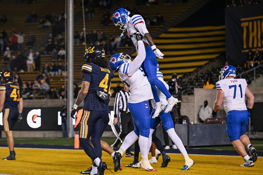 SMU offensive lineman Abel Hoopii (58) lifts running back Chris Johnson Jr. (6) after Johnson Jr. scored a touchdown during the first half of an NCAA college football game against California, Saturday, Nov. 29, 2025, in Berkeley, Calif. (AP Photo/Justine Willard)