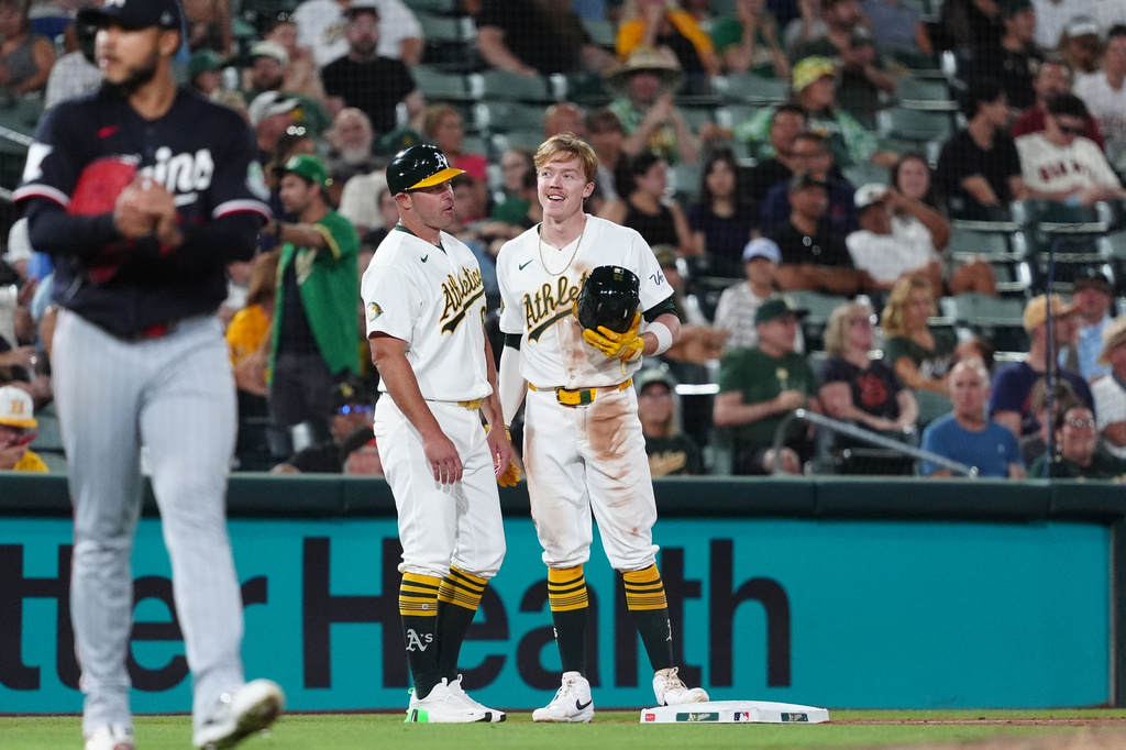 Athletics Henry Bolte, center, talks with Athletics third base coach Bobby Crosby (8) after hitting a triple during the seventh inning of a baseball game against the Minnesota Twins Tuesday, Aug. 25, 2026, in West Sacramento, Calif. (AP Photo/Alan Greth)