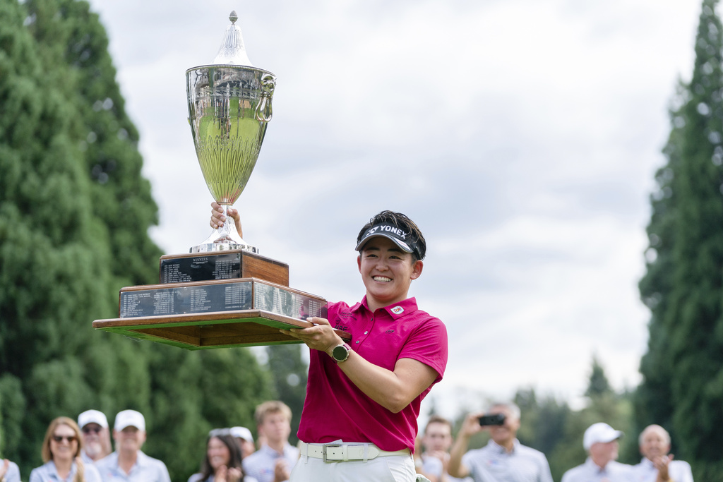 Akie Iwai, of Japan, holds up the trophy after winning the LPGA Portland Classic golf tournament at Columbia Edgewater in Portland, Ore., Sunday, Aug. 17, 2025. (AP Photo/Ali Gradischer)