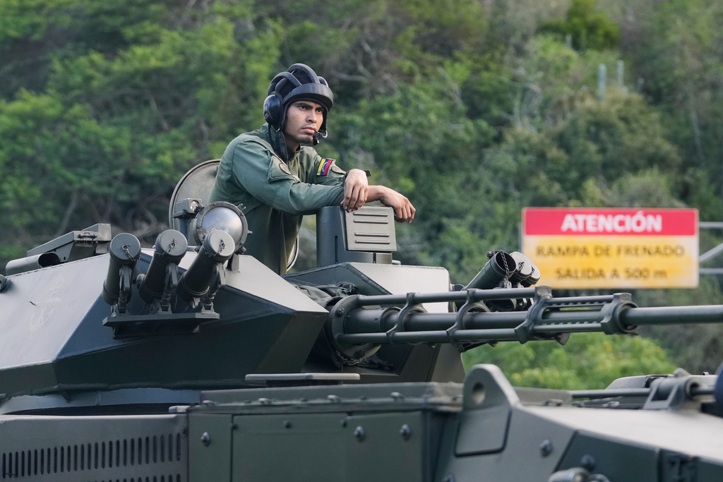 A soldier stands atop an armored vehicle driving toward Caracas, Venezuela, Sunday, Jan. 4, 2026. (AP Photo/Matias Delacroix)