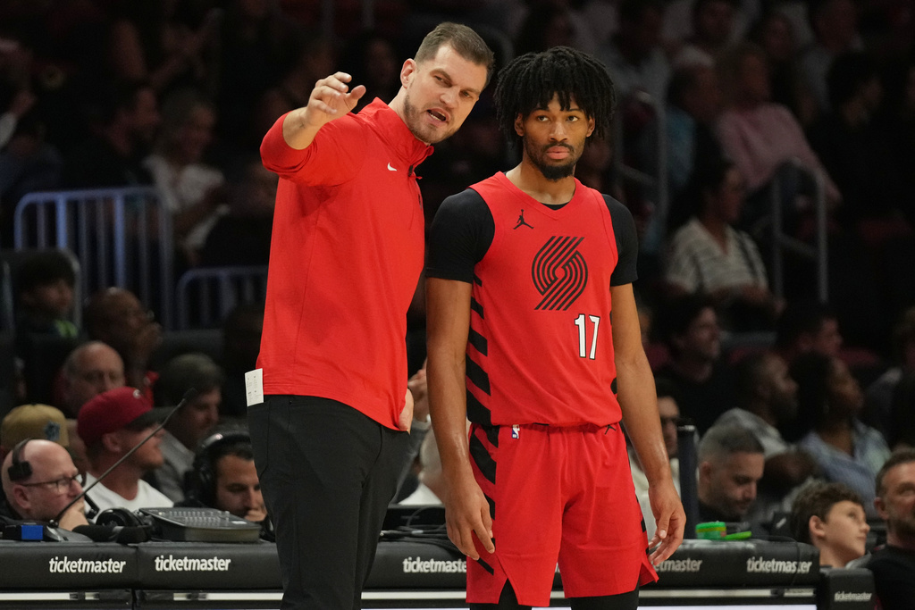 Portland Trail Blazers acting head coach Tiago Splitter, left talks with guard Shaedon Sharpe (17) during the first half of an NBA basketball game against the Miami Heat, Saturday, Nov. 8, 2025, in Miami. (AP Photo/Lynne Sladky)