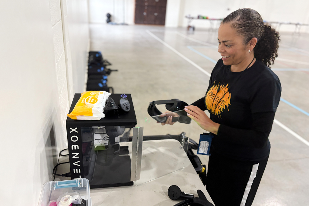 Sabra Williams, Co-Founder of Creative Acts, cleans virtual reality headsets inside Valley State Prison in Chowchilla, Calif., Dec. 11, 2025. (AP Photo/Haven Daley)