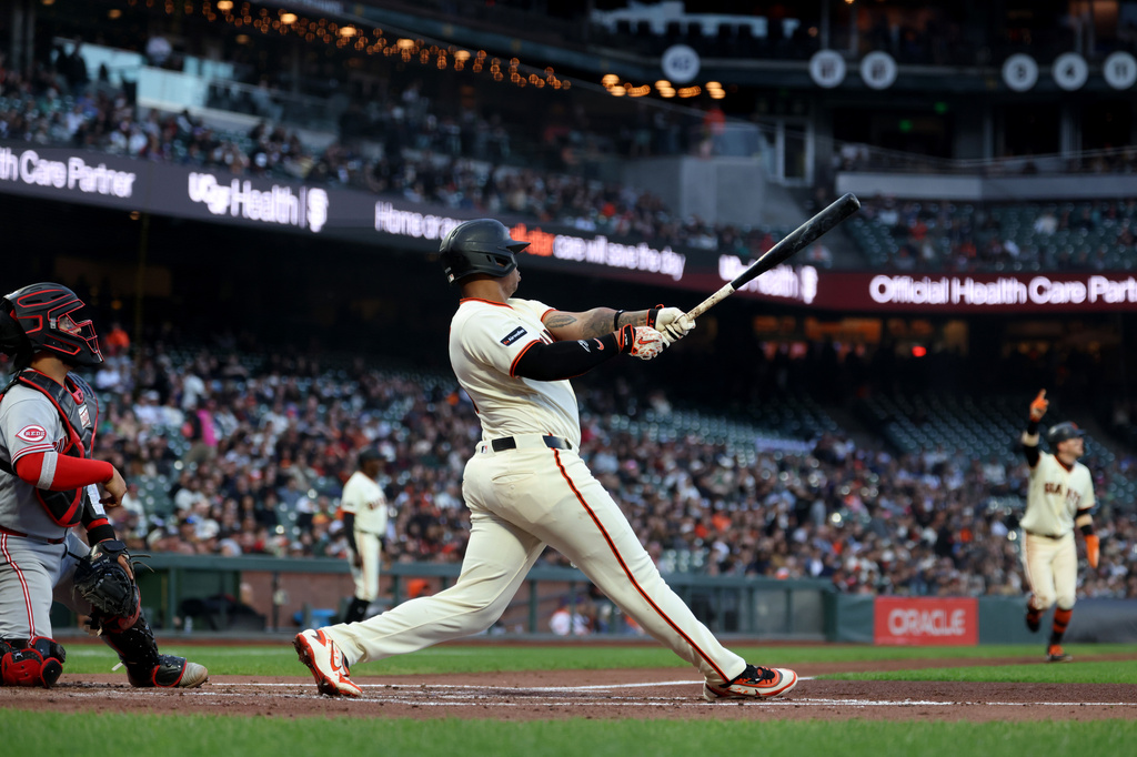 San Francisco Giants' Rafael Devers, right, watches his three-run home run in front of Cincinnati Reds catcher Jose Trevino, left, during the second inning of a baseball game in San Francisco, Monday, Aug. 24, 2026. (AP Photo/Jed Jacobsohn)