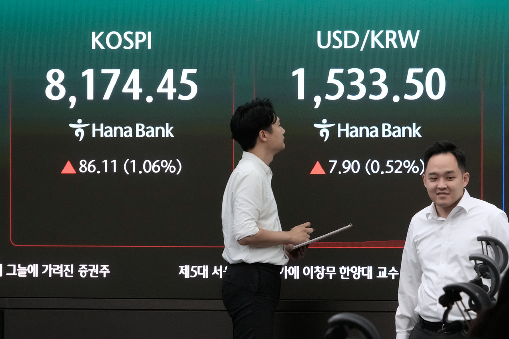 Currency traders pass by a screen showing the Korea Composite Stock Price Index (KOSPI) and the foreign exchange rate between U.S. dollar and South Korean won at the foreign exchange dealing room of the Hana Bank headquarters in Seoul, South Korea, Monday, July 6, 2026. (AP Photo/Ahn Young-joon)