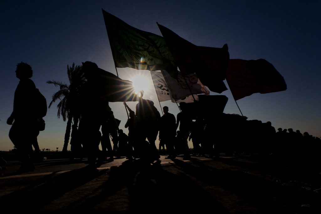 The sun rises as Shiite pilgrims march on their way, to Karbala, to observe Arbaeen that marks the end of a 40-day mourning period following the Day of Ashura, in Najaf, Iraq, Tuesday, July 28, 2026. (AP Photo/Anmar Khalil)