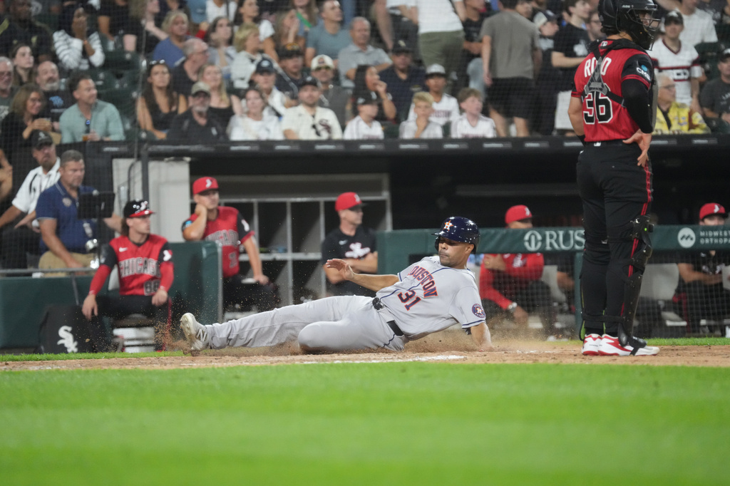 Houston Astros' LaMonte Wade Jr, left, is safe at as Chicago White Sox catcher Drew Romo, right, stands nearby during the sixth inning of a baseball game Friday, July 24, 2026, in Chicago. (AP Photo/David Banks)