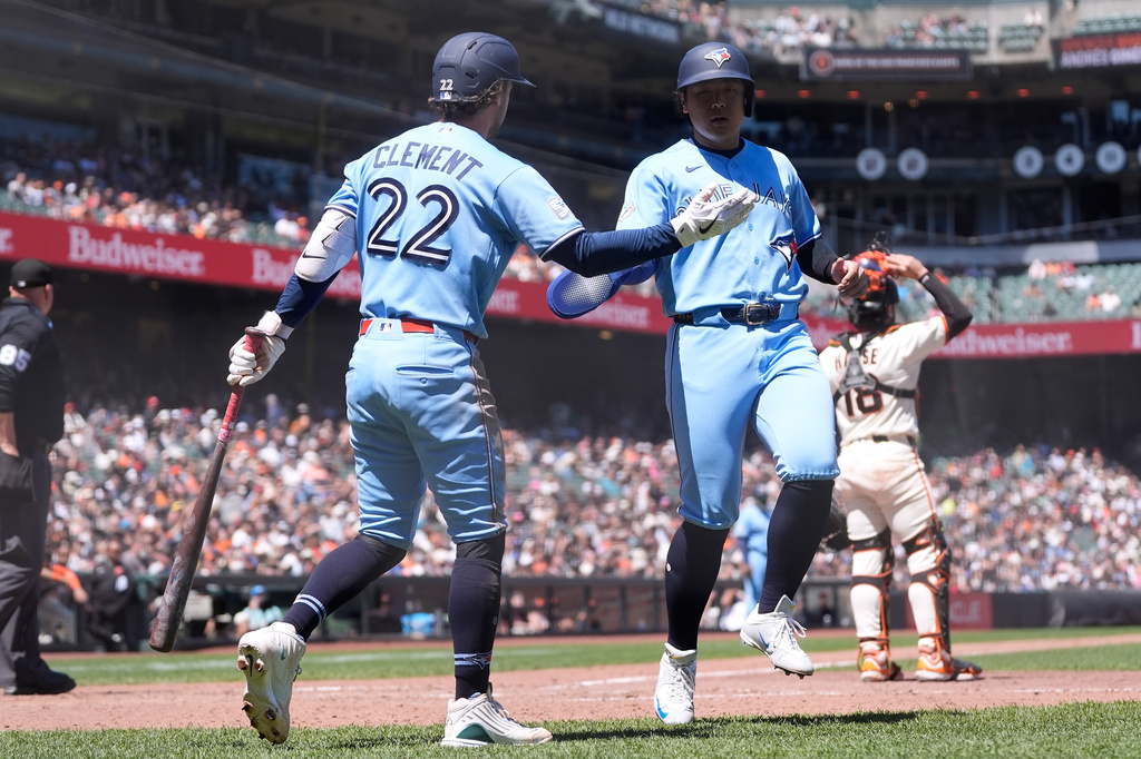 Toronto Blue Jays' Kazuma Okamoto, right, is congratulated by Ernie Clement (22) after scoring against the San Francisco Giants during the eighth inning of a baseball game Wednesday, July 8, 2026, in San Francisco. (AP Photo/Jeff Chiu)