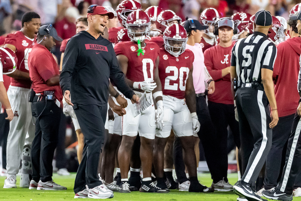 Alabama head coach Kalen DeBoer, front left, talks with a referee during a timeout in the first half of an NCAA college football game against Louisiana-Monroe, Saturday, Sept. 6, 2025, in Tuscaloosa, Ala. (AP Photo/Vasha Hunt)