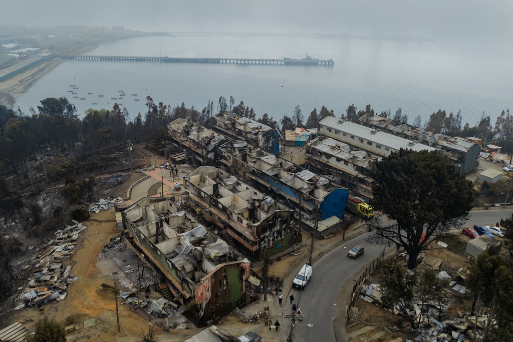 Buildings lie damaged by wildfires near Lirquen, Chile, Tuesday, Jan. 20, 2026. (AP Photo/Javier Torres)