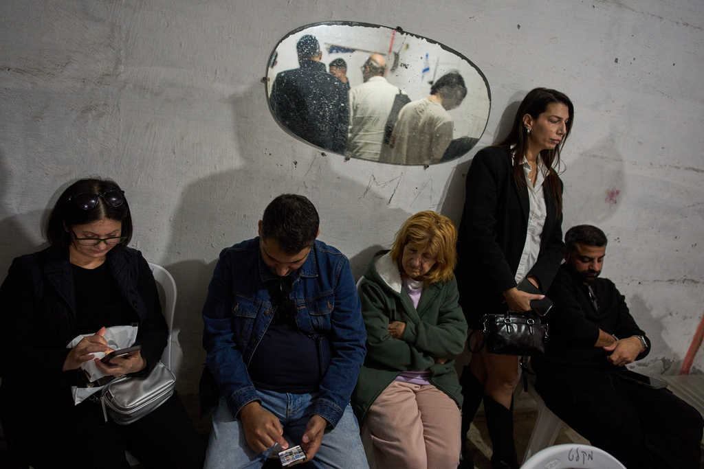 People take cover in an underground bomb shelter as air raid sirens warn of incoming Iranian missile strike, in Ramat Gan, Israel, Wednesday, March 11, 2026. (AP Photo/Oded Balilty)