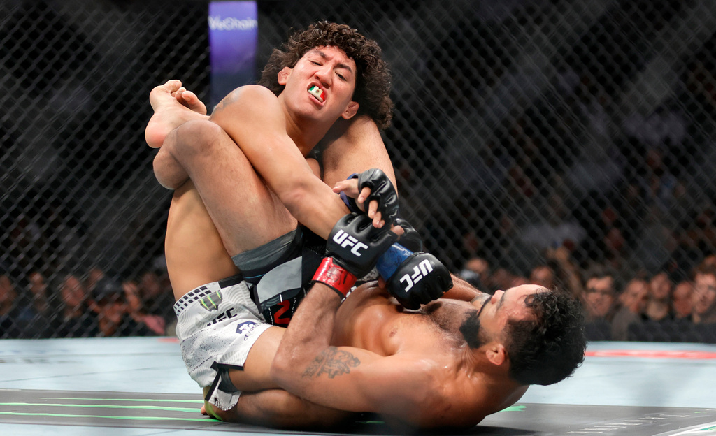Raul Rosas Jr., top, grapples with Rob Font, bottom, in a bantamweight mixed martial arts bout during UFC 326, Saturday, March 7, 2026, in Las Vegas. (Steve Marcus/Las Vegas Sun via AP)