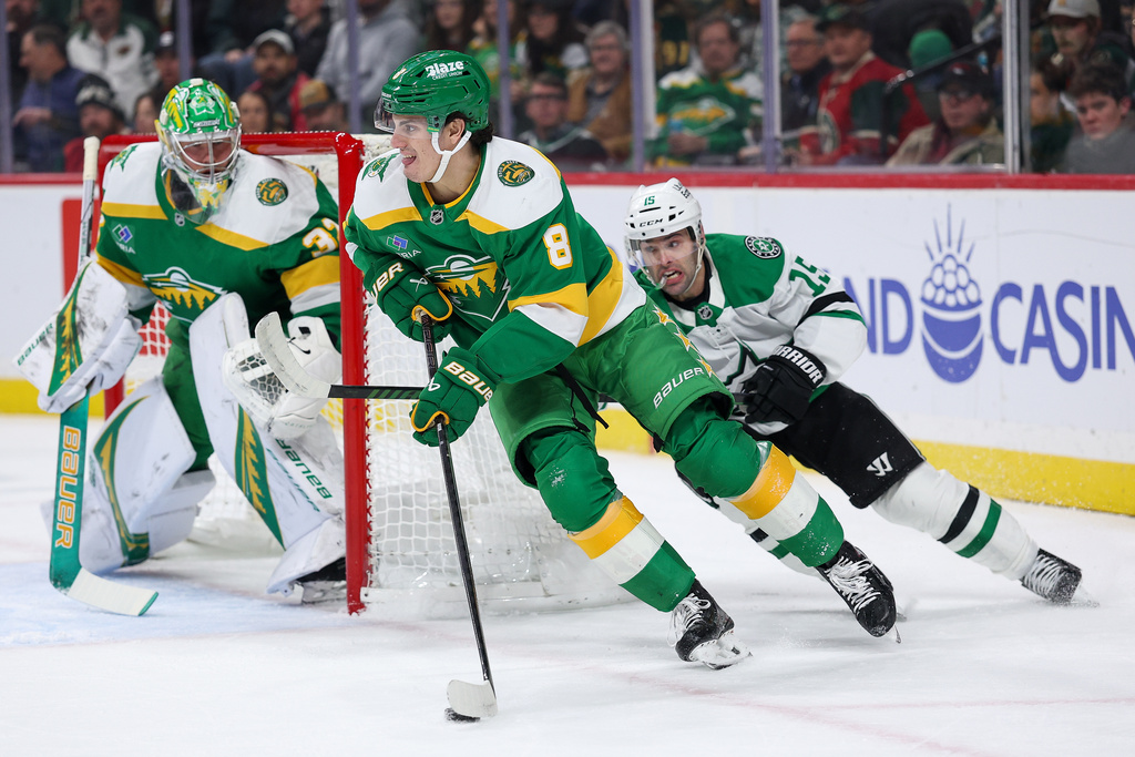 Minnesota Wild defenseman Zeev Buium, left, skates with the puck as Dallas Stars center Colin Blackwell (15) defends during the first period of an NHL hockey game Thursday, Dec. 11, 2025, in St. Paul, Minn. (AP Photo/Matt Krohn)