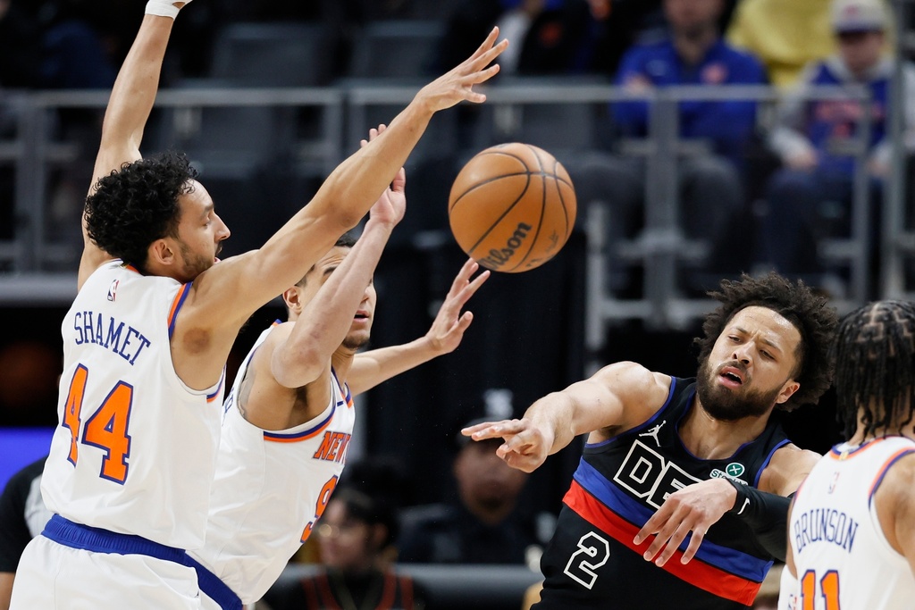 Detroit Pistons guard Cade Cunningham (2) passes the ball against New York Knicks guard Landry Shamet (44) and guard Kevin McCullar Jr. (9) during the first half of an NBA basketball game Friday, Feb. 6, 2026, in Detroit. (AP Photo/Duane Burleson)