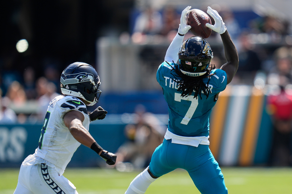 Jacksonville Jaguars wide receiver Brian Thomas Jr. (7) pulls in a reception in front of Seattle Seahawks safety Coby Bryant during the first half of an NFL football game Sunday, Oct. 12 2025, in Jacksonville, Fla.(AP Photo/John Raoux)