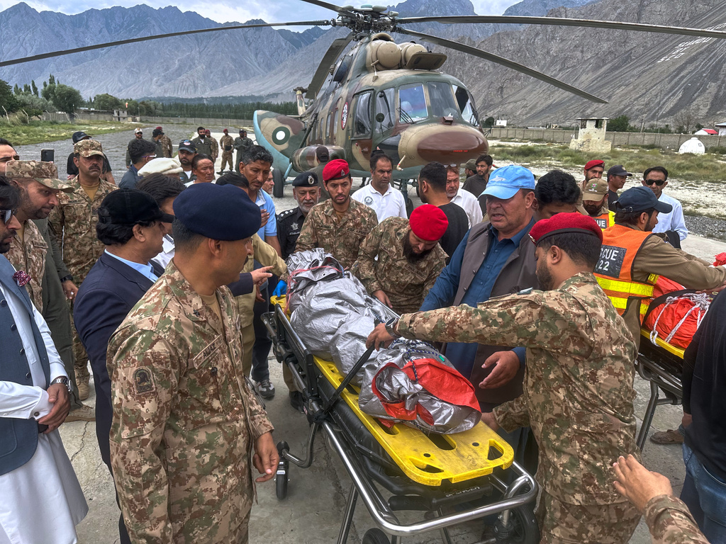 Pakistani army soldiers and volunteers prepare to load into ambulances, the bodies of climbers, that were recovered from Broad Peak nearly a week after an avalanche swept away a 10-member international expedition, upon arrival at a military base in Skardu, in northern Pakistan, Thursday, Aug. 6, 2026. (AP Photo/ M.H. Balti)