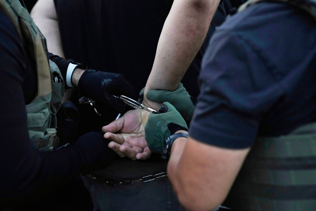 FILE - U.S. Immigration and Customs Enforcement agents make an arrest during an early morning operation in Park Ridge, Ill., Sept. 19, 2025. (AP Photo/Erin Hooley, File)