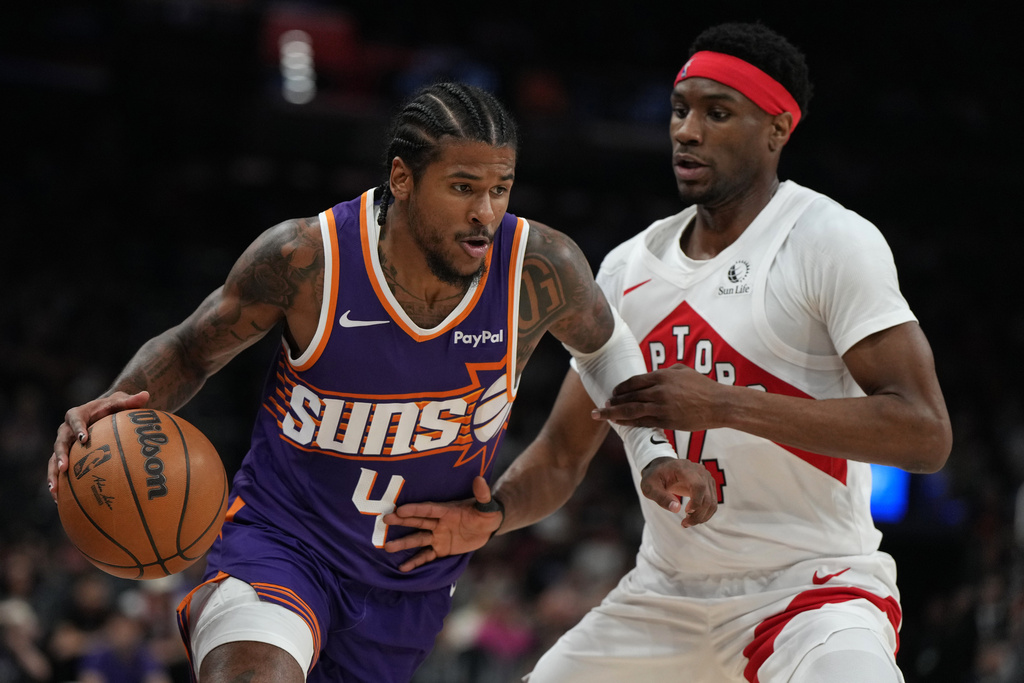 Phoenix Suns guard Jalen Green (4) drives past Toronto Raptors guard Ja'kobe Walter during the first half of an NBA basketball game, Sunday, March 23, 2026, in Phoenix. (AP Photo/Rick Scuteri)