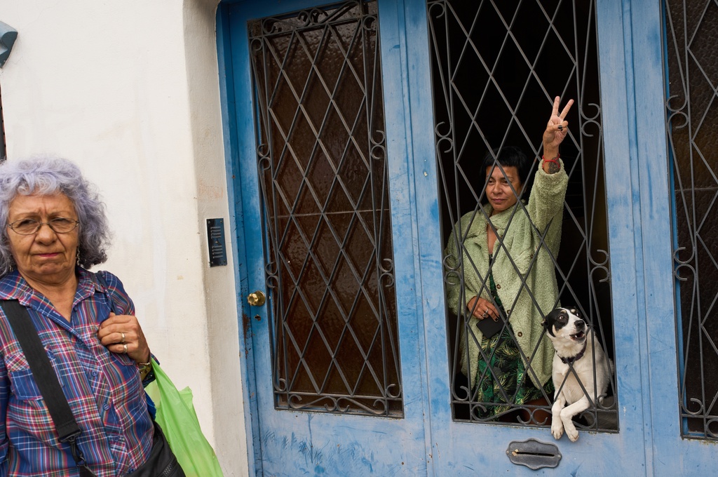 A woman flashes a V for victory hand sign from her house toward people protesting human rights violations committed during Argentina's dictatorship, one week before the March 24, 1976 military coup anniversary that brought the regime to power, in Buenos Aires, Argentina, Saturday, March 14, 2026. (AP Photo/Rodrigo Abd)