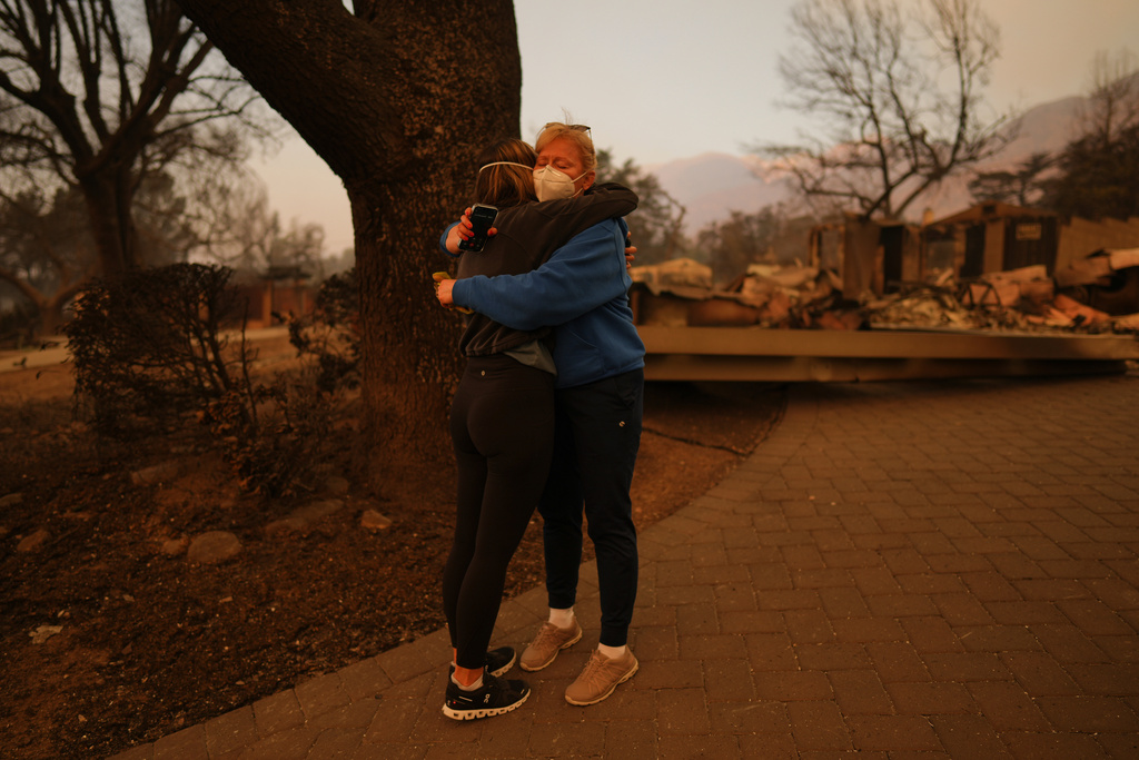 FILE - Melissa Young, center right, gets a hug from a well-wisher at her fire-ravaged home in the aftermath of the Eaton Fire, Jan. 9, 2025, in Altadena, Calif. (AP Photo/Eric Thayer, File)