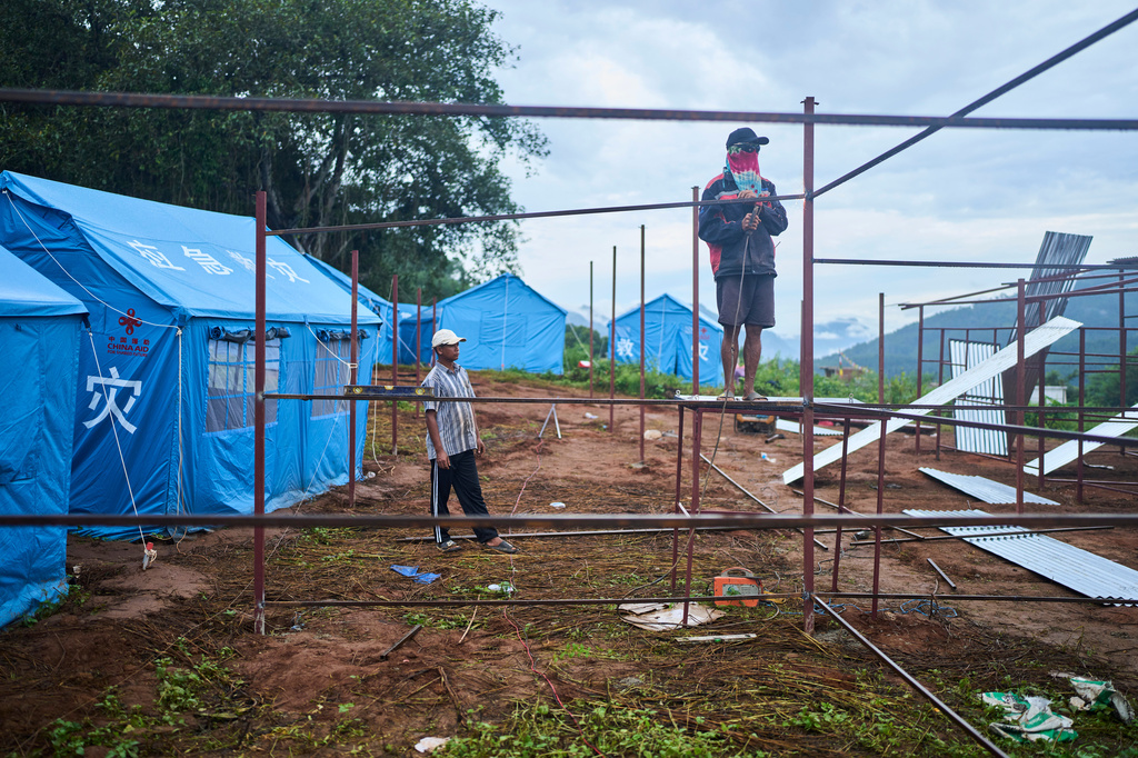 Workers weld metal frames while building temporary shelters for survivors of recent flash floods in Nepal's Nuwakot district, Wednesday, Sept. 23, 2026. (AP Photo/Niranjan Shrestha)